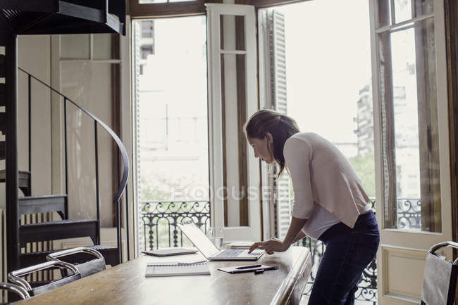 Женщина, использующая ноутбук дома — стоковое фото
