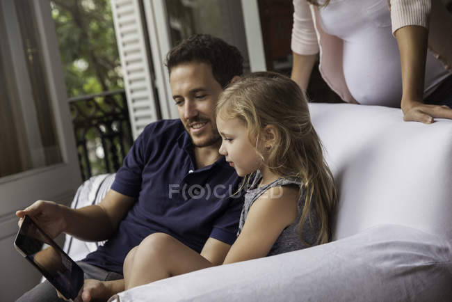Семья с помощью цифрового планшета вместе дома — стоковое фото