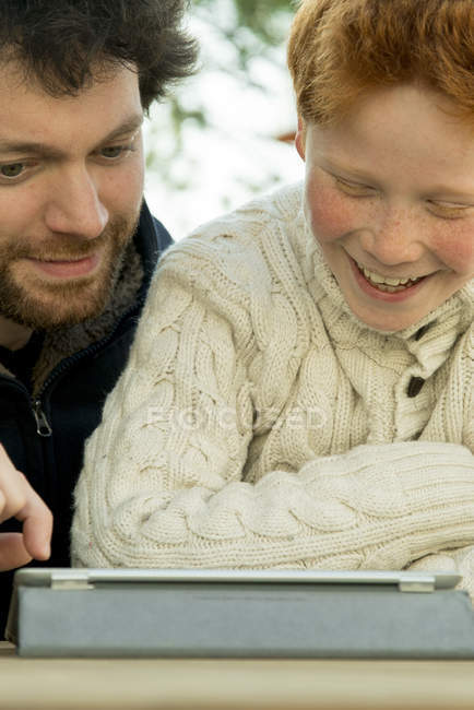 Pai e filho usando tablet digital juntos — Fotografia de Stock