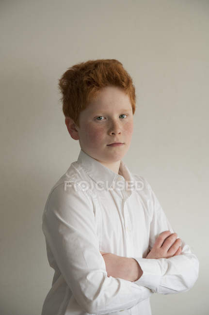Портрет мальчика со сложенными на сером фоне руками — стоковое фото