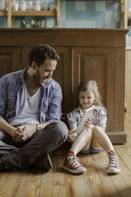 Mädchen zeigt Vater digitales Tablet zu Hause — Stockfoto