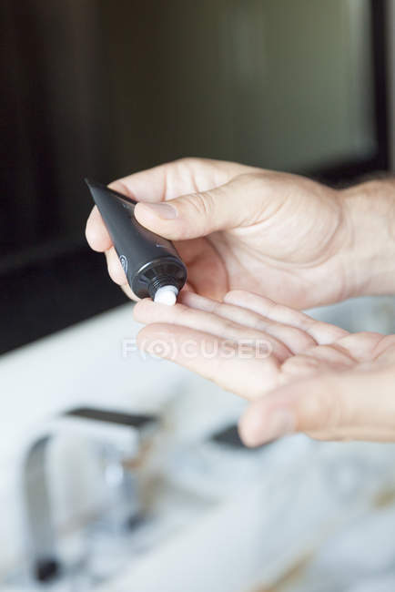 Man applying moisturizer to hands, cropped — Stock Photo