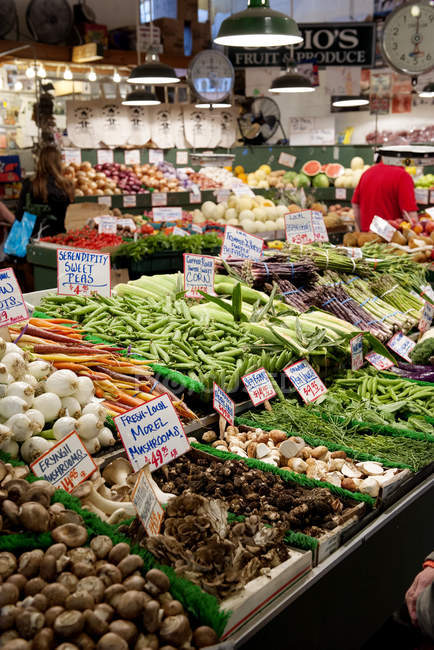 Produtos frescos em supermercado com pessoa em segundo plano — Fotografia de Stock