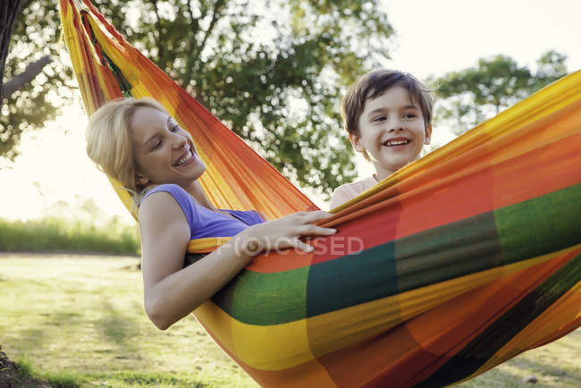Mãe e filho relaxando juntos em rede — Fotografia de Stock