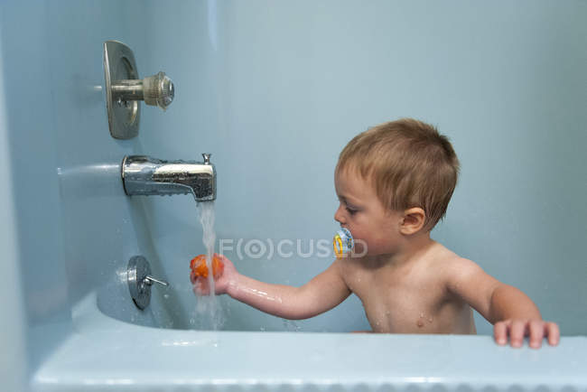 Хлопчик Тоддлер приймає ванну з іграшкою — стокове фото