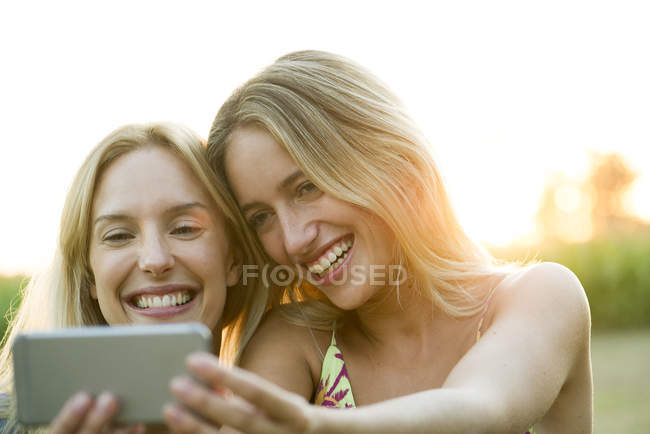 Couple féminin posant pour selfie sur smartphone — Photo de stock