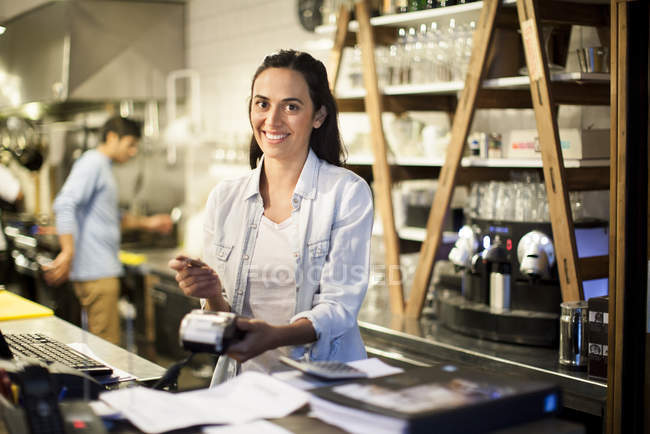 Жінка використовує читач кредитних карток в ресторані — стокове фото