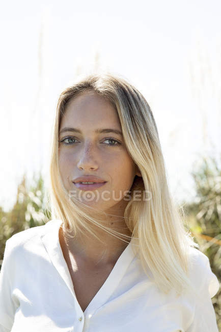 Retrato de jovem mulher séria olhando para a câmera ao ar livre — Fotografia de Stock