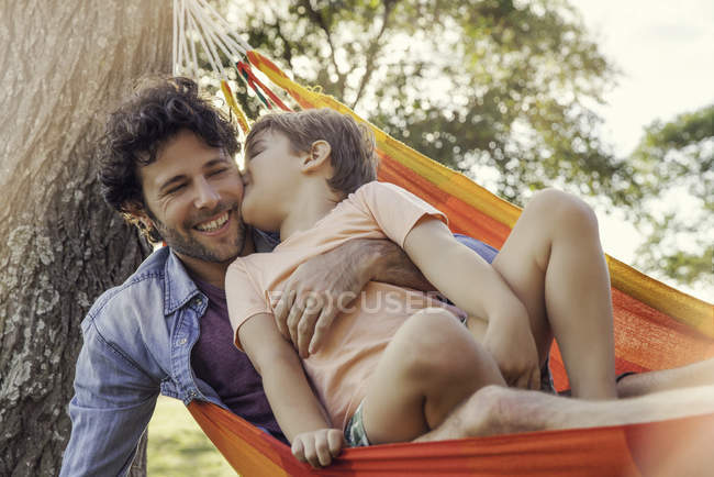 Отец и сын отдыхают вместе в гамаке — стоковое фото