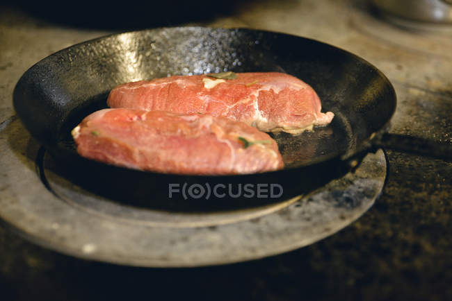 Perto de fritar costeletas de porco na panela — Fotografia de Stock