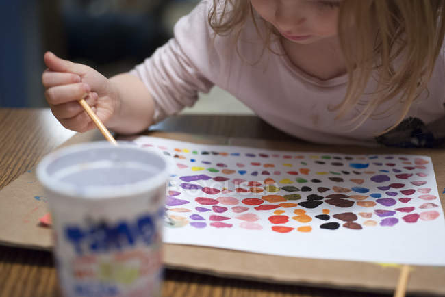 Маленькая девочка рисует акварелью — стоковое фото