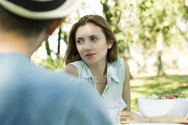 Femme au pique-nique dans le parc avec un ami — Photo de stock