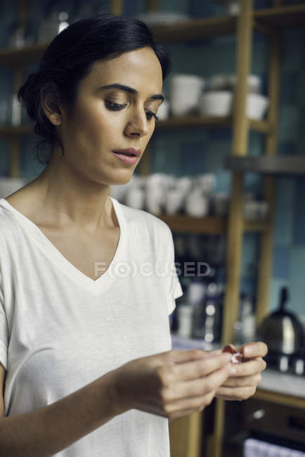Jovem mulher tomando pílula em casa — Fotografia de Stock