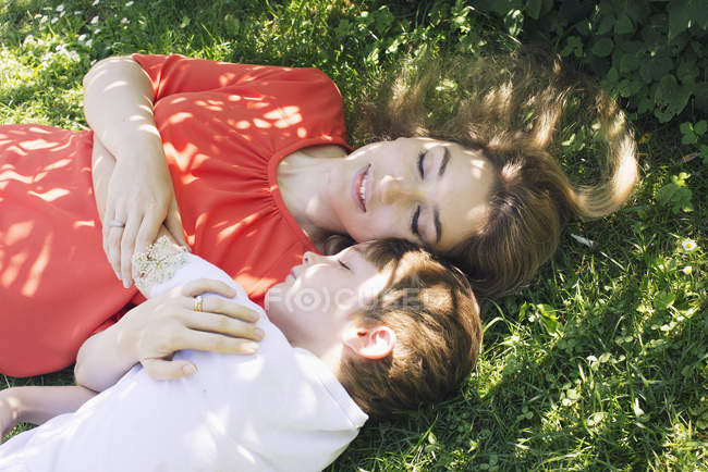 Overhead view of mother and son napping on grass — Stock Photo