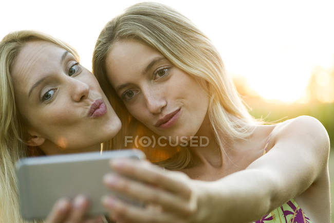 Жіноча пара позує за селфі на смартфоні — стокове фото