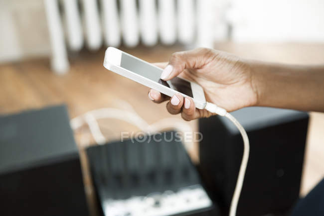 Imagen recortada de la mano de las mujeres utilizando el teléfono inteligente con pantalla táctil - foto de stock