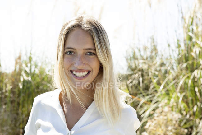 Retrato de la mujer sonriendo alegremente al aire libre - foto de stock
