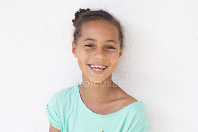 Retrato de feliz sonriente chica afroamericana contra la pared blanca - foto de stock