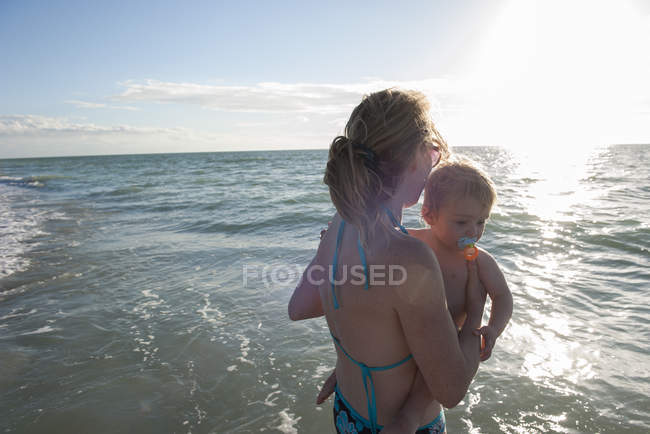 Mère pataugeant dans l'eau avec tout-petit garçon — Photo de stock