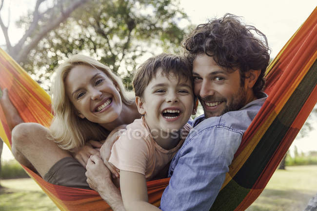 Retrato de familia relajante con hamaca al aire libre - foto de stock
