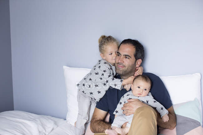 Père avec bébé garçon et jeune fille dans le lit — Photo de stock