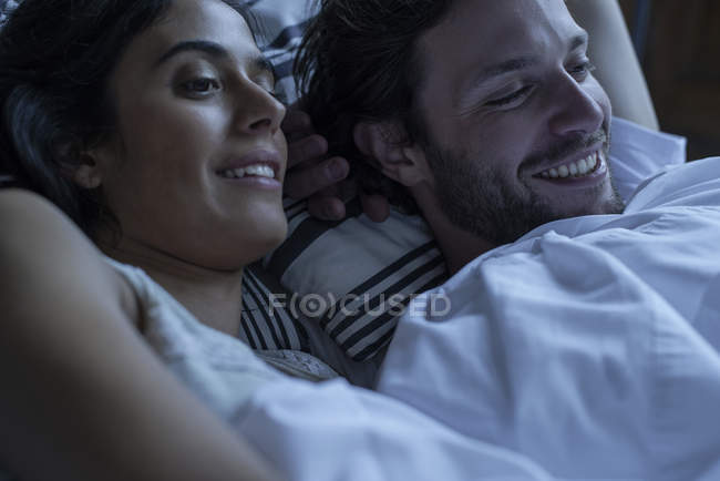 Пара смотрит телевизор вместе в постели — стоковое фото
