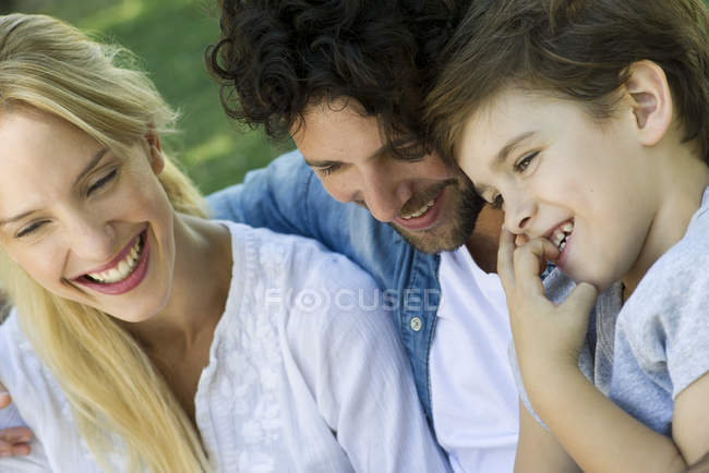 Familia con un niño relajándose juntos al aire libre picnic - foto de stock