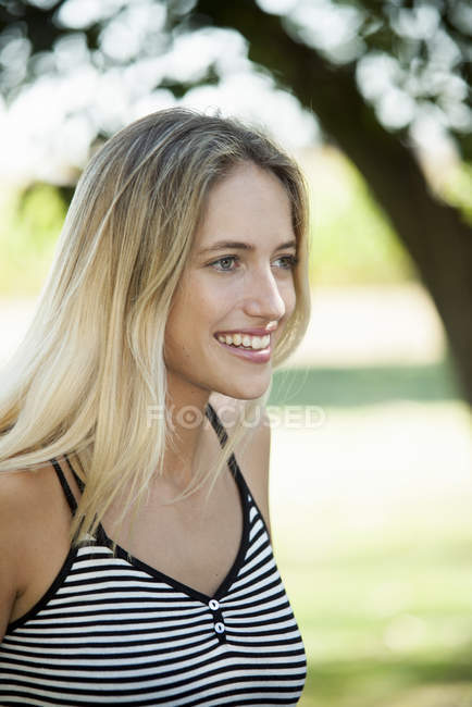 Портрет усміхненої блондинки, яка дивиться на відкритому повітрі — стокове фото