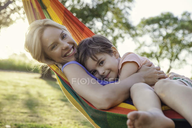 Madre e hijo que relajan en la hamaca juntos - foto de stock