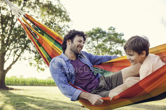 Pai e filho relaxando juntos em rede — Fotografia de Stock