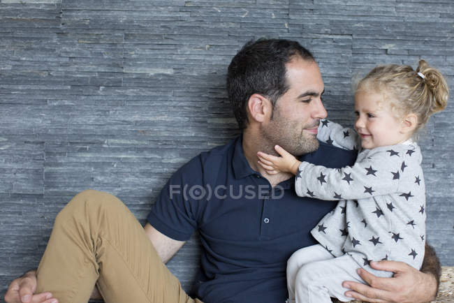 Retrato de padre e hija contra pared de madera - foto de stock