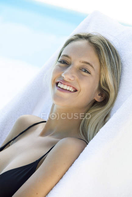 Ritratto di donna che si rilassa accanto alla piscina — Foto stock