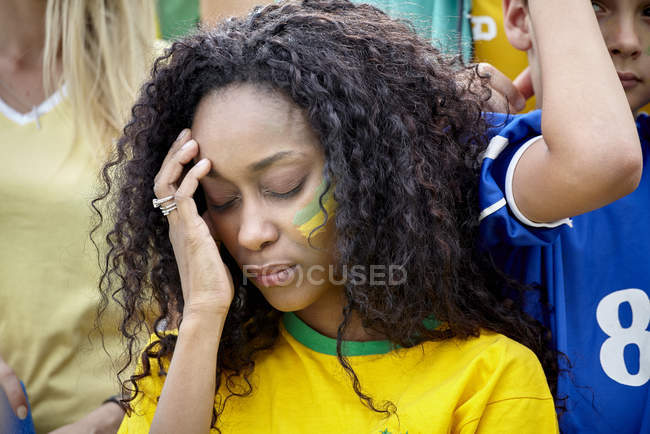 Woman holding head in disappointment at Brazilian football match — Stock Photo