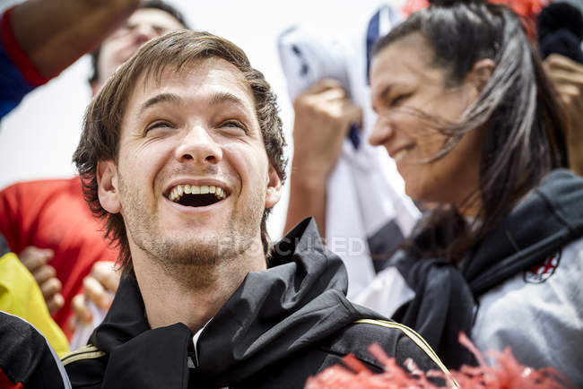 Fútbol fans sonriendo alegremente en el partido - foto de stock