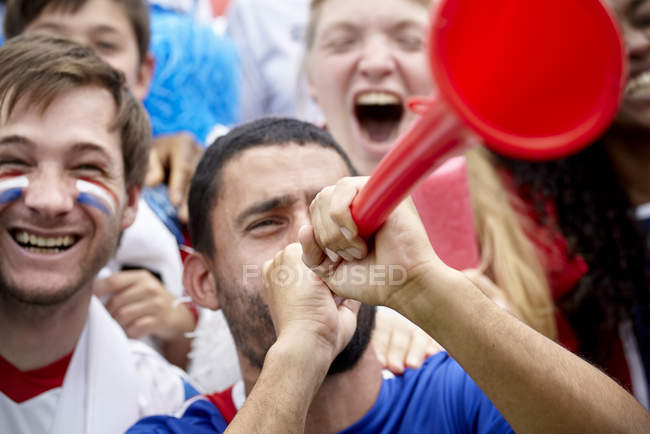 French football supporter playing vuvuzela at match — Stock Photo