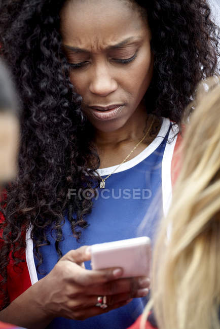Жінка дивиться на смартфон з тривожним виразом обличчя — стокове фото