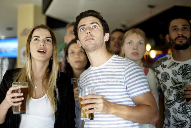 Entusiastas del deporte viendo partido en el bar - foto de stock