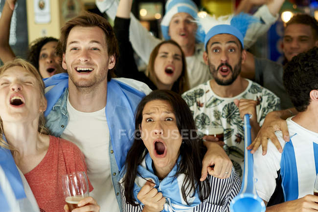 Fãs de futebol argentinos assistindo jogo juntos no pub — Fotografia de Stock