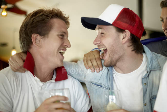 Sports enthusiasts celebrating together in bar — Stock Photo