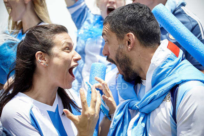 Aficionados argentinos al fútbol gritando entusiasmados en el partido - foto de stock
