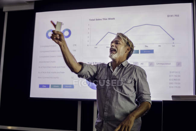 Hombre dando presentación en pantalla de proyección - foto de stock