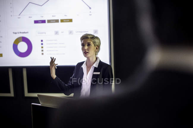 Mulher dando apresentação na tela de projeção — Fotografia de Stock