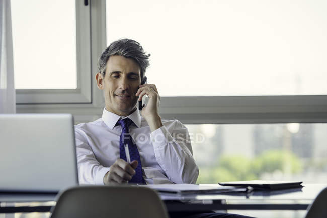 Man in office talking on phone in the office — Stock Photo