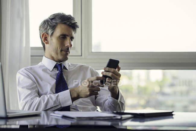 Человек, использующий смартфон в офисе — стоковое фото