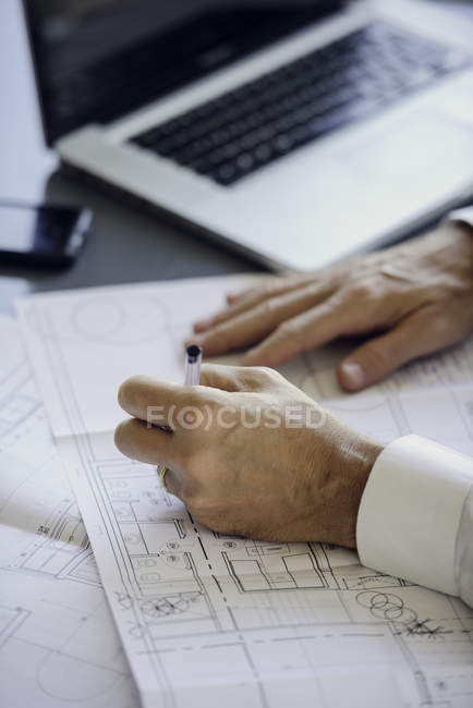 Homme travaillant avec des plans dans le bureau — Photo de stock