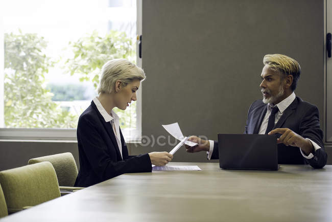 Жінка і чоловік в офісі читають документи — стокове фото