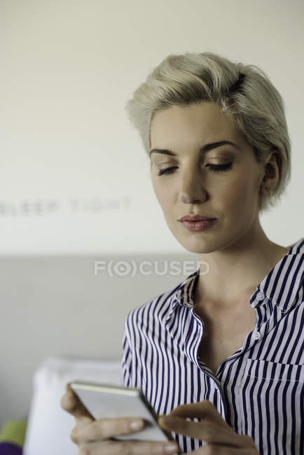 Woman using smart phone at hotel room — Stock Photo