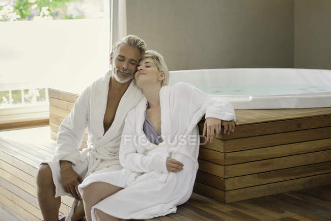Casal em roupões de banho relaxante no spa — Fotografia de Stock