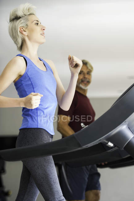 Mulher e homem correndo em esteiras — Fotografia de Stock