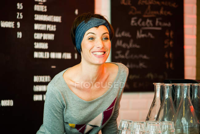 Retrato de sorrindo Mulher de pé no balcão no restaurante — Fotografia de Stock